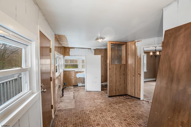 611-615 S New York Rd, Galloway Township, NJ 08205 - corridor featuring baseboard heating, wooden walls, healthy amount of natural light, brick patterned floors, and a chandelier