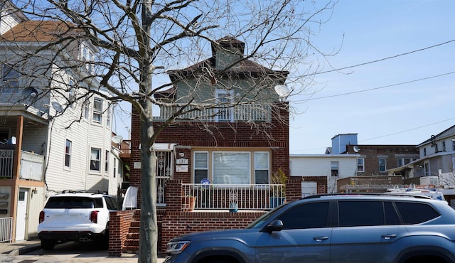 view of front of house featuring brick siding and a chimney