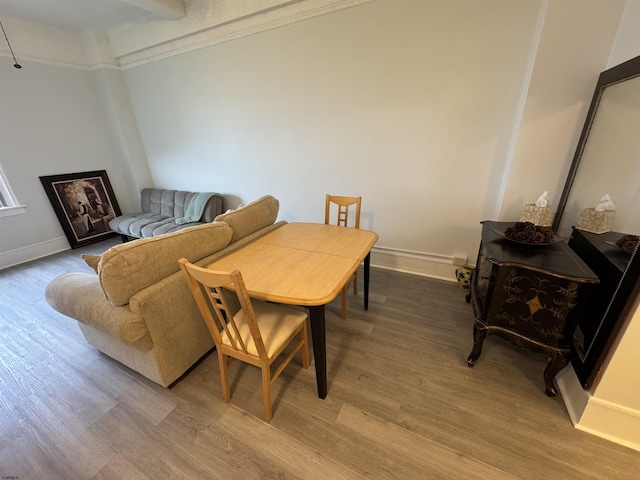 living room with light wood-type flooring, baseboards, and crown molding