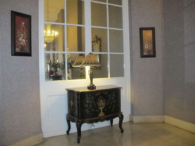 room details with wallpapered walls, a notable chandelier, and baseboards