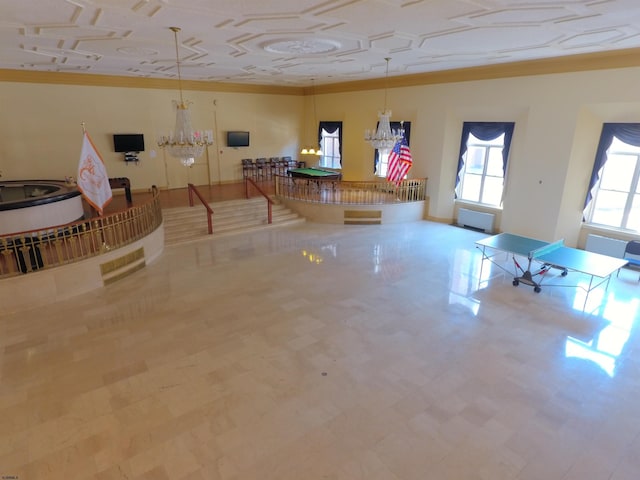 interior space with a chandelier, tile patterned floors, baseboards, and ornamental molding