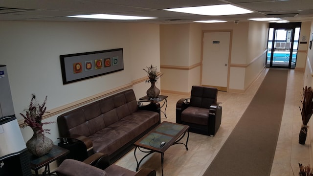 living room with a paneled ceiling