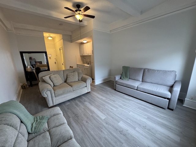 living room featuring ceiling fan, baseboards, and wood finished floors