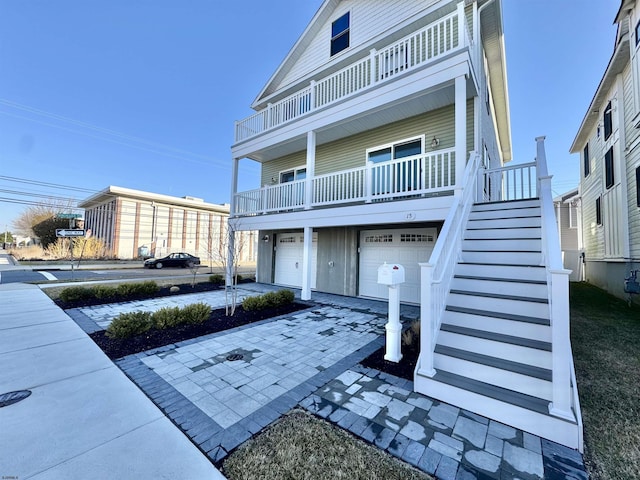 view of front of house with an attached garage, stairway, and driveway