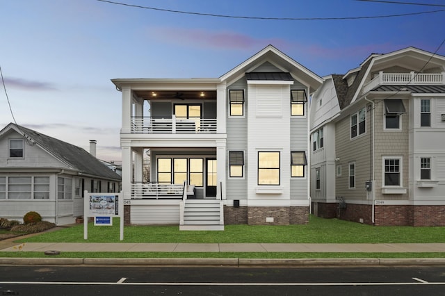 view of front of home with covered porch, a lawn, crawl space, and a balcony