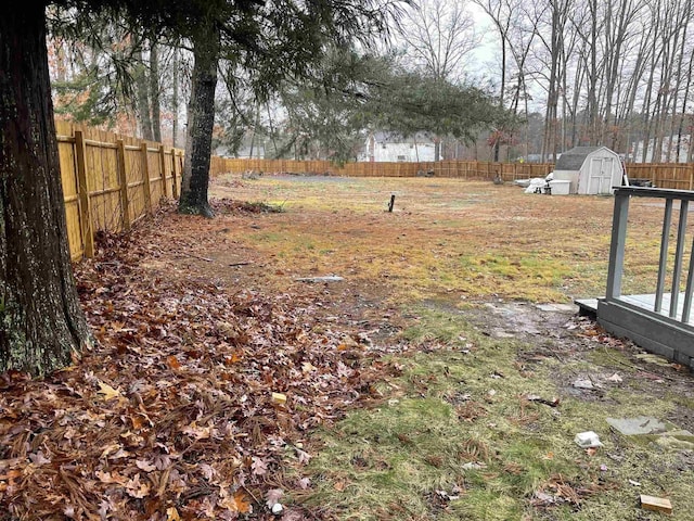 view of yard with a fenced backyard, an outdoor structure, and a storage shed