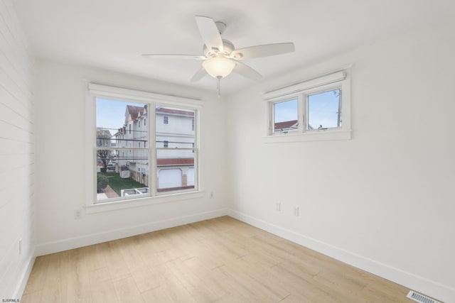unfurnished room featuring ceiling fan, baseboards, light wood-style floors, and visible vents