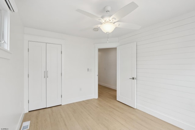 unfurnished bedroom with light wood finished floors, baseboards, visible vents, a ceiling fan, and a closet