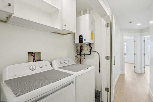 laundry room featuring baseboards, recessed lighting, light wood-style floors, water heater, and washer and dryer