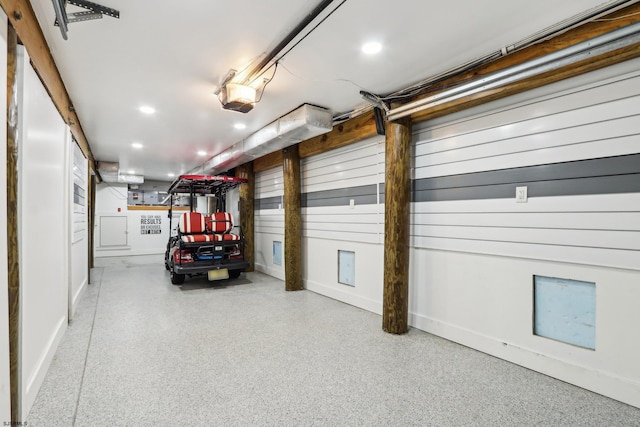 garage with baseboards, a garage door opener, and recessed lighting