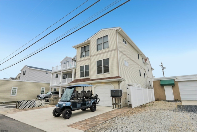 back of house featuring an attached garage, driveway, and fence