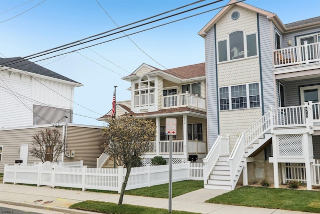 view of front of home featuring fence and a balcony
