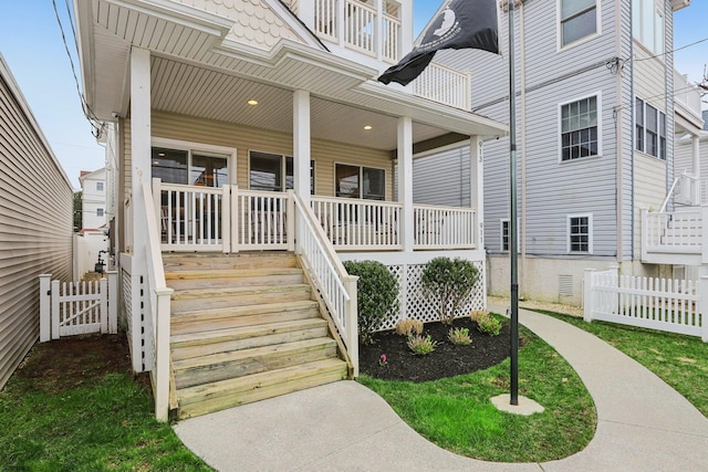 entrance to property with fence and covered porch