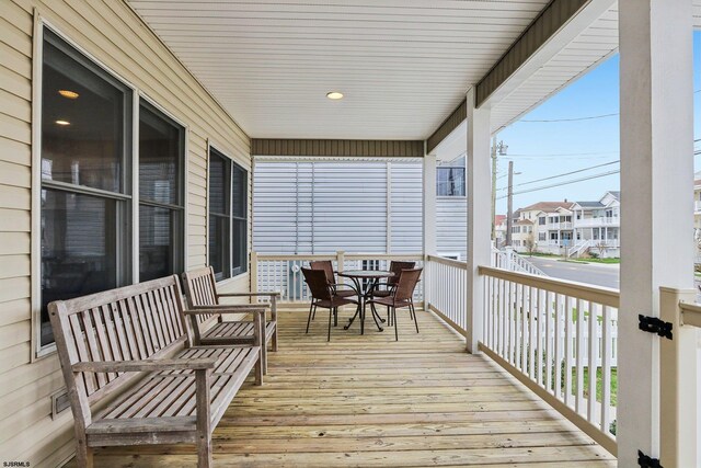 wooden terrace featuring a residential view and outdoor dining area