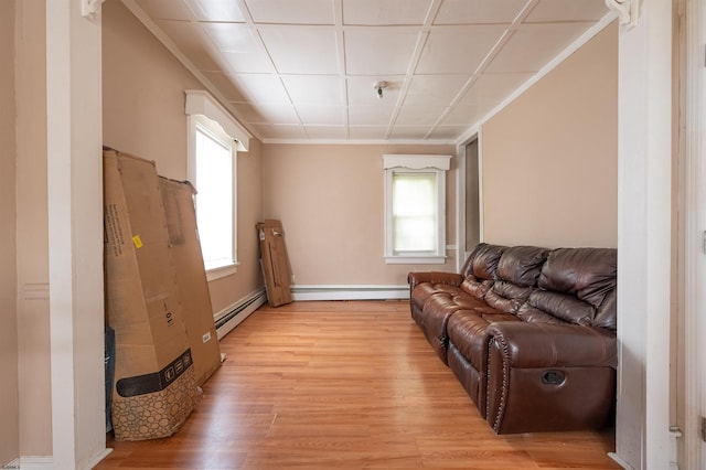 living area featuring a baseboard heating unit and light wood finished floors