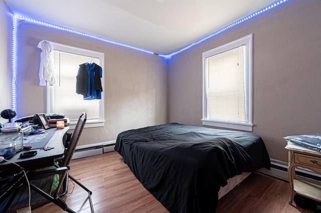 bedroom featuring a baseboard heating unit, wood finished floors, and a baseboard radiator