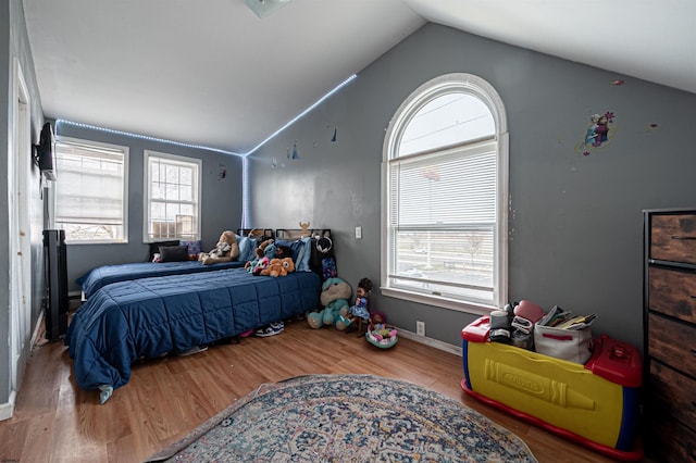 bedroom with vaulted ceiling and wood finished floors