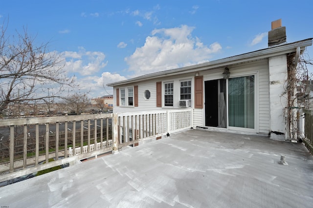 exterior space with a wooden deck, cooling unit, and a chimney