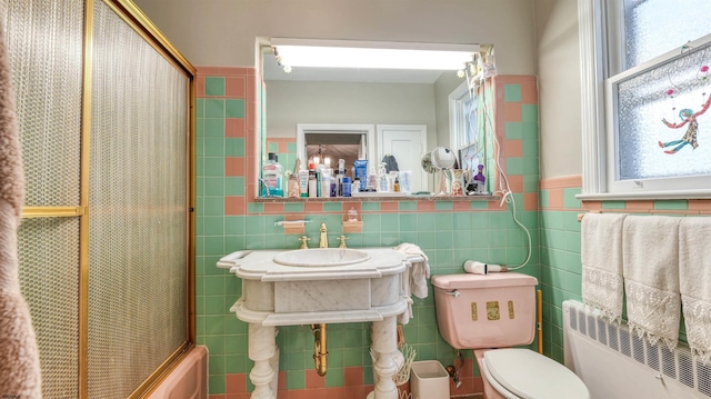 full bath featuring tile walls, toilet, a healthy amount of sunlight, and radiator