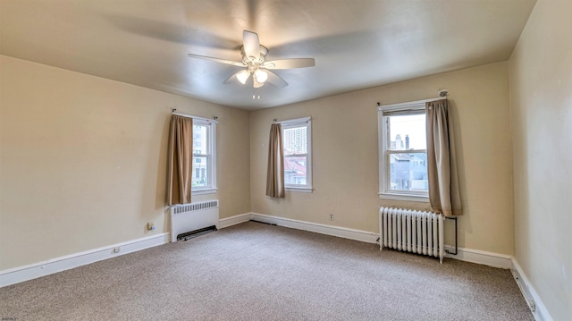 empty room featuring radiator, radiator heating unit, carpet floors, and ceiling fan