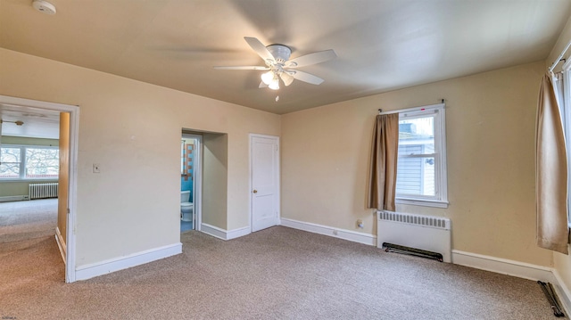 carpeted spare room with radiator, radiator heating unit, baseboards, and ceiling fan