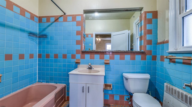 full bath with toilet, tile walls, radiator heating unit, vanity, and shower / tub combination