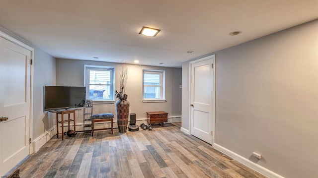 living area with baseboards, wood finished floors, and recessed lighting