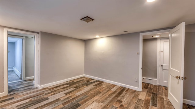 unfurnished room with recessed lighting, wood finished floors, and baseboards