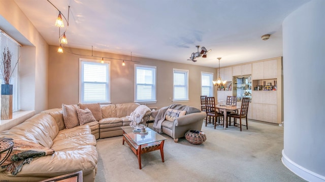 living room with carpet flooring, a wealth of natural light, and a notable chandelier