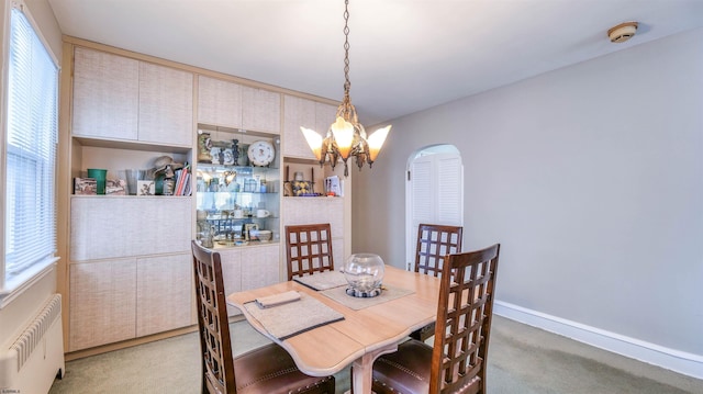 dining area featuring radiator heating unit, light carpet, a chandelier, and plenty of natural light