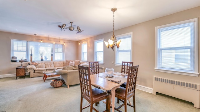 dining area with radiator, an inviting chandelier, baseboards, and carpet