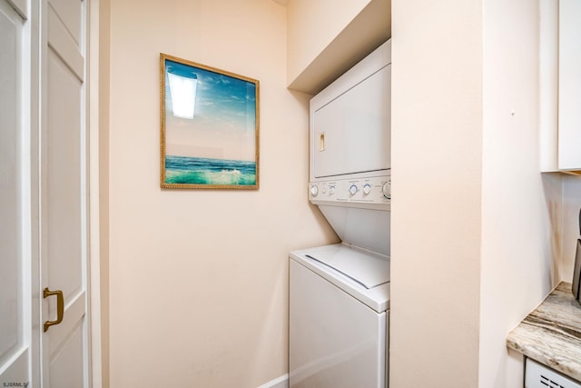 clothes washing area with stacked washer and clothes dryer and laundry area