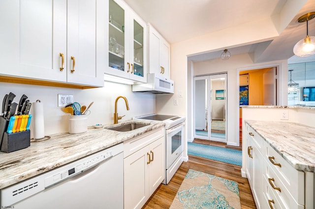 kitchen featuring white appliances, glass insert cabinets, light wood-style flooring, a sink, and white cabinetry