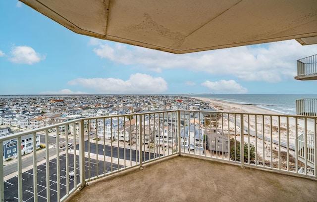 balcony featuring a view of the beach and a water view