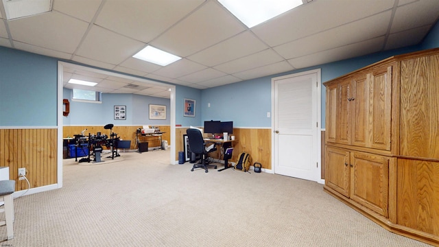 carpeted office with wainscoting, a paneled ceiling, and wooden walls