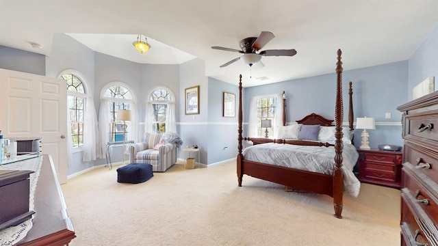 bedroom with ceiling fan, baseboards, and light colored carpet