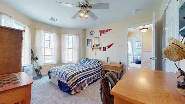 bedroom featuring ceiling fan, carpet floors, multiple windows, and visible vents
