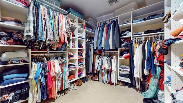 walk in closet with visible vents and carpet