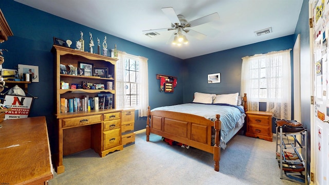 bedroom featuring light colored carpet, a ceiling fan, and visible vents