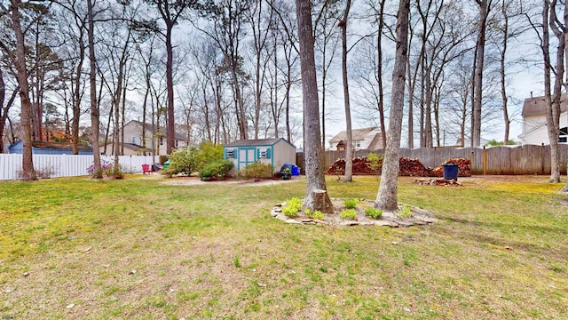 view of yard featuring an outdoor structure, a residential view, and a fenced backyard