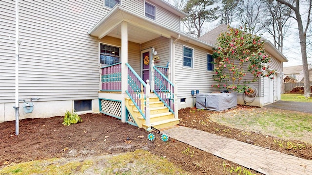property entrance with crawl space, aphalt driveway, and covered porch