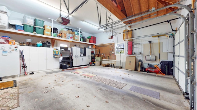 garage with freestanding refrigerator and a garage door opener