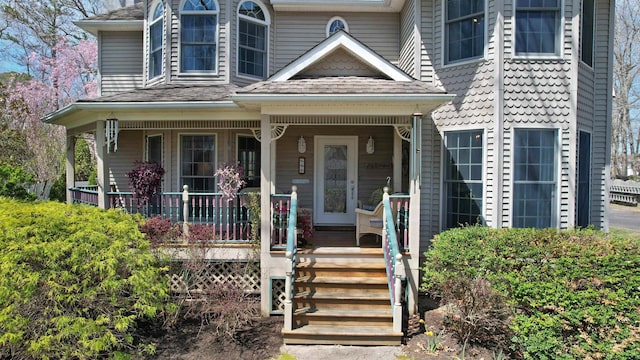 view of front of house featuring a shingled roof and covered porch
