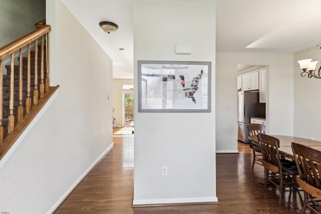 interior space with stairway, an inviting chandelier, dark wood-style flooring, and baseboards
