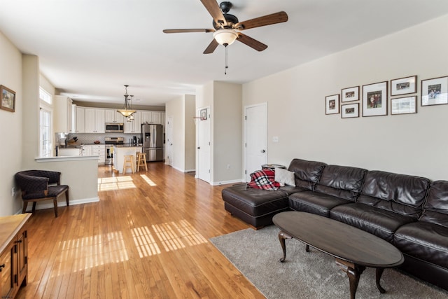 living area featuring a ceiling fan and light wood-style flooring