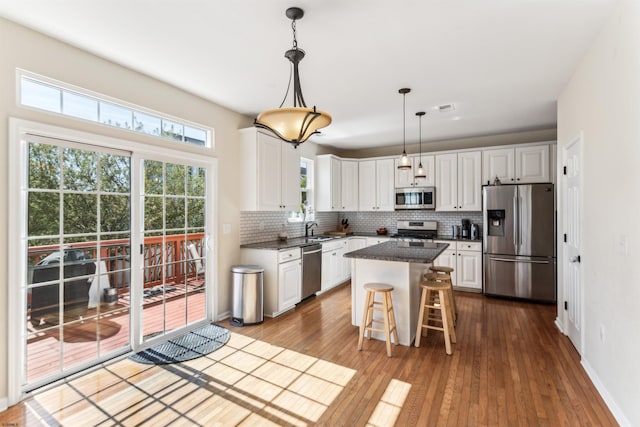 kitchen with white cabinets, visible vents, dark wood-type flooring, decorative backsplash, and appliances with stainless steel finishes