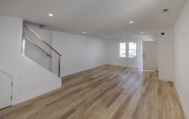 interior space with baseboards, visible vents, light wood finished floors, and stairs