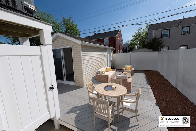 wooden terrace with an outdoor structure, outdoor dining area, and a fenced backyard