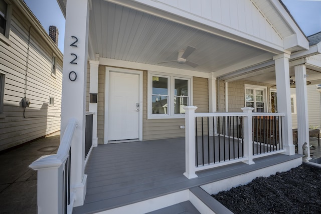 doorway to property featuring board and batten siding, ceiling fan, and covered porch