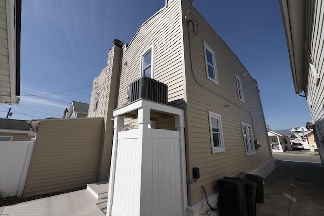 view of property exterior featuring fence and cooling unit